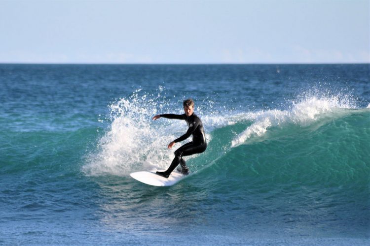 Clean surf conditions as a surfer rides a wave at Black Rock